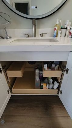 a bathroom sink under a mirror with drawers underneath it