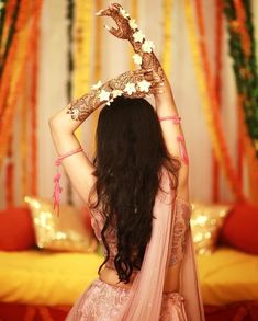 a woman in a pink lehenga is holding her hands up to her head