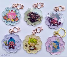 six keychains with cartoon characters on them are shown in different colors and sizes