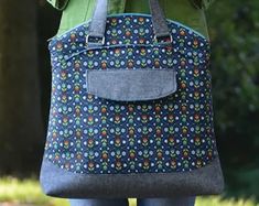 a woman carrying a blue bag with flowers on it