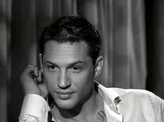 a black and white photo of a man in a shirt with his hand on his head