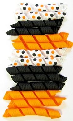 four pieces of orange and black paper with polka dots on them, all stacked up in the same row