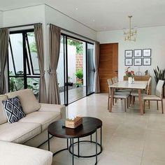 a living room filled with furniture next to a dining table and large glass doors leading outside