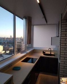 an empty kitchen with large windows overlooking the city