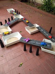 a toy car track made out of cement blocks and black plastic cones on the ground