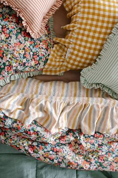 a person laying in bed with many pillows