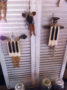 two old fashioned musical instruments are hanging on the wall next to jars with lids and spoons