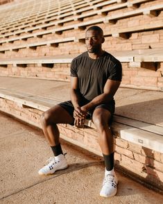 a man is sitting on the bleachers with his legs crossed