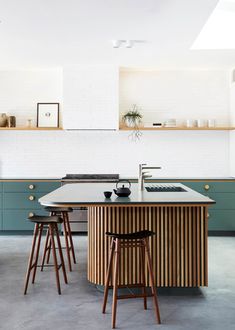 a kitchen island with stools in front of it