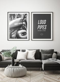 two black and white posters hanging on the wall above a gray couch in a living room