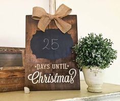 a wooden sign that says 25 days until christmas with a potted plant next to it