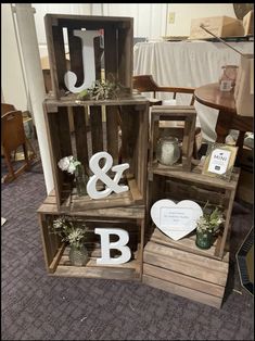 three wooden crates with letters and plants in them sitting on the floor next to each other