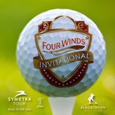 the four winds golf tournament logo on top of a white ball with green grass in the background