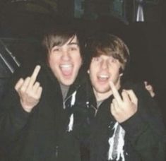 two young men giving the peace sign with their fingers