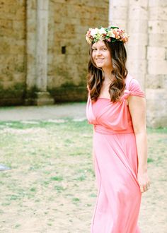 a woman wearing a flower crown standing in front of an old building