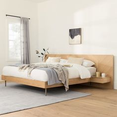 a bed sitting on top of a hard wood floor next to a white bedroom wall