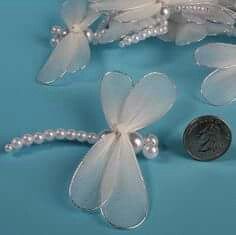 three white flowers and pearls on a blue background next to a dime for the penny