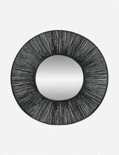 a round mirror with black and white lines on it's face, reflecting the light