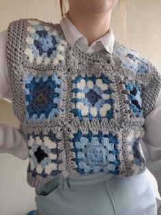 a woman is wearing a crocheted vest with flowers on it