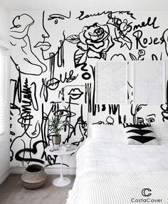 a bedroom with black and white graffiti wallpaper on the walls, along with a bed
