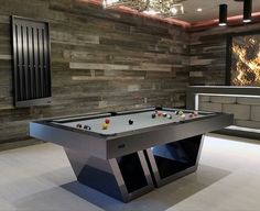 a pool table in the middle of a room with wood paneling on the walls