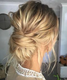 a woman with blonde hair in a low bun braided into a messy updo