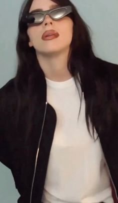 a woman with glasses on her face wearing a white t - shirt and black jacket