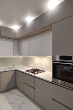 a kitchen with marble counter tops and white cupboards on the walls, along with a stove top oven