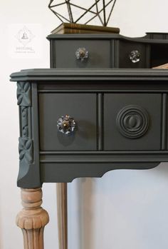 a black dresser with drawers and knobs on it