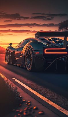 a black sports car driving down the road at sunset