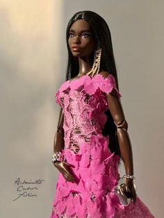 a barbie doll wearing a pink dress and holding a handbag in her right hand