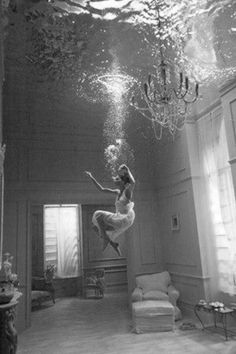 a woman is jumping in the air under water