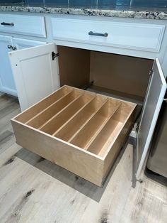 an open drawer in the middle of a kitchen