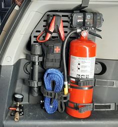 an emergency kit in the back of a car with tools attached to it and other items