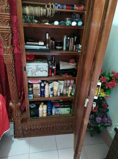 a wooden cabinet filled with lots of different types of cosmetics and other things in it