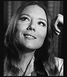 black and white photograph of woman in library with bookshelves behind her, looking up at the sky