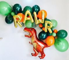 a dinosaur balloon with the word rap spelled out in gold, green, and orange balloons