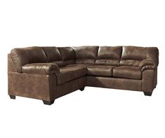 a large brown sectional couch sitting on top of a white floor