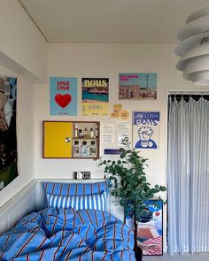 a bed sitting in a bedroom next to a window covered in pictures and posters on the wall