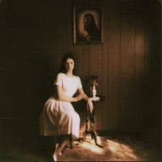 a woman sitting in a chair next to a table