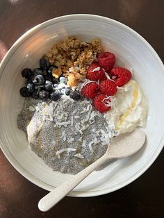 a bowl filled with granola, yogurt and berries