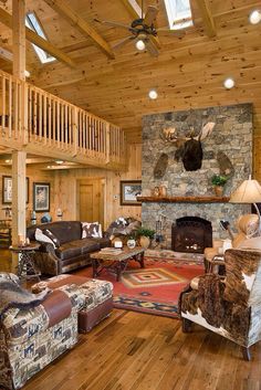 a living room filled with furniture and a fire place in the middle of a wooden floor