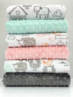 five baby blankets stacked on top of each other