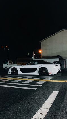 a white sports car parked in front of a building