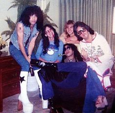 a group of people posing for a photo in a living room with one woman sitting on the couch