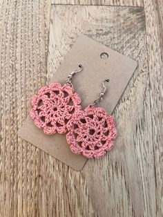 pink crochet earrings on top of a wooden table