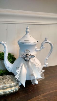 a white tea pot sitting on top of a wooden table