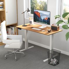 a desk with a computer on it and a chair next to it in front of a window