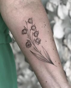 a woman's arm with a flower tattoo on the left side of her arm