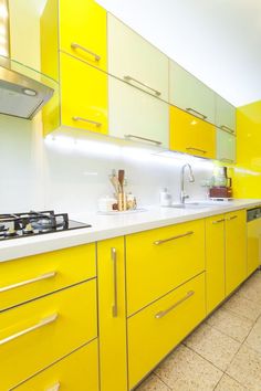 a kitchen with yellow cabinets and white counter tops